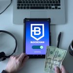 Tablet com representação de tecnologia blockchain, dinheiro em espécie e itens de escritório sobre uma mesa.