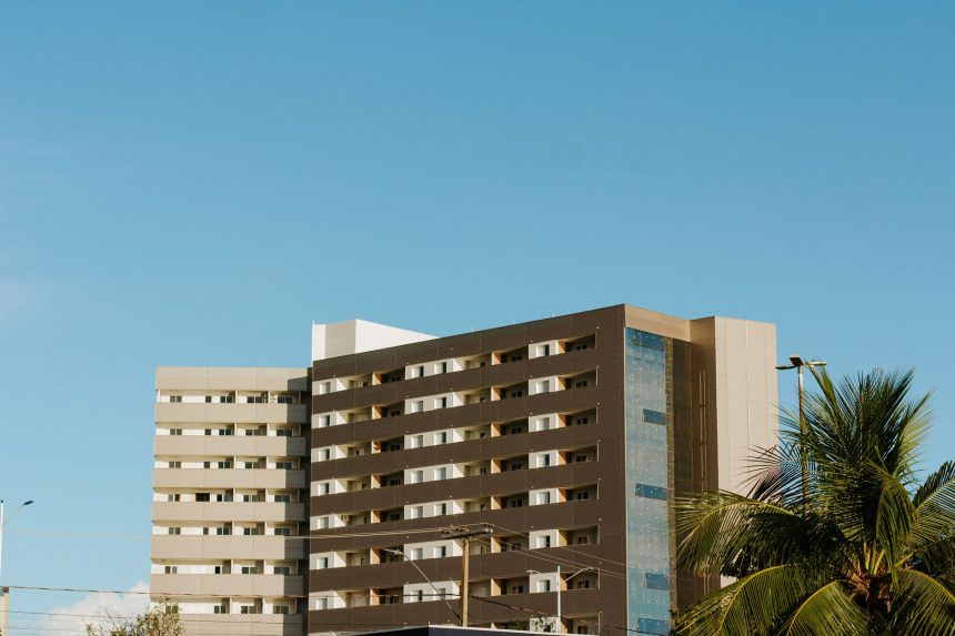 Edifício contemporâneo em Palmas, no Tocantins, cercado por palmeiras sob céu azul.